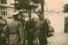 Offiziere der Wehrmacht im Gespräch auf einem Platz im Balkan