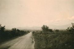 Landstraße in Balkanregion mit Bergpanorama und Siedlung