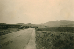 Landstraße in Balkanregion mit Militärkonvoi und Berglandschaft