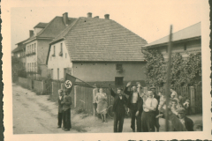 Straßenszene in Polen mit NS-Flagge und Zivilbevölkerung