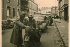 Straßenszene in Sedan mit Militärpersonal und Motorrad
