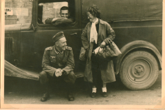 Offizier der Wehrmacht mit Zivilist an Lastkraftwagen