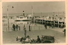 Hafenszene mit Passagierschiff und Zivilbevölkerung