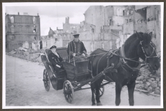 Kriegsmarine-Angehörige mit Pferdekutsche in zerstörter Stadt