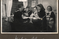 Marinesoldat und Zivilpersonen bei Kartenspielen in Innenraum