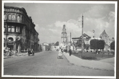 Stadtplatz mit Kirchturm und Kriegsschäden an Wohngebäude