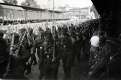 Militärische Versammlung mit Fahnenaufmarsch an Eisenbahnanlage