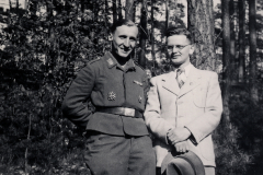 Zwei M?nner im Wald, einer in Uniform mit Abzeichen