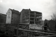 Zerstörte Wohngebäude mit Opel-Werbeschild in kriegszerstörter Stadt
