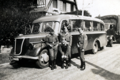 Uniformierte Personen vor Omnibus in Wohngebiet