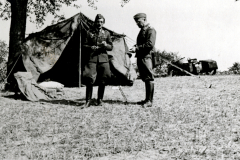 Soldaten vor Feldlager mit Zelt und Ausrüstung