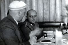 Besprechung zwischen Zivilist und Luftwaffenoffizier an Schreibtisch