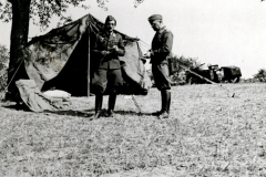 Soldaten vor Feldlager mit Zelt und Ausrüstung