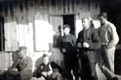 Personen vor Baracke in Winterkleidung