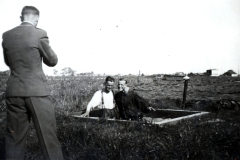 Mann in Anzug fotografiert zwei Personen in Feldlandschaft