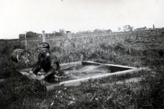 Soldat an Feldstellung mit Wassergraben und Stacheldrahtverhauen