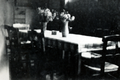 Innenraum mit Tisch, Stühlen und Blumenvase
