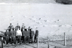 Soldatengruppe an Strandposition mit Drahtverhauen und Landungsfahrzeug