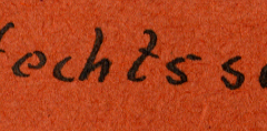 Handschriftliche Beschriftung auf orangefarbenem Untergrund