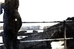 Soldat an Befestigungsanlage mit Blick auf Hafenstadt