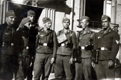 Uniformierte Soldaten in Gruppenaufstellung vor Gebäude