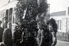 Deutsche Soldaten bei Weihnachtsdekoration vor Fahrzeug und Wohngebäude