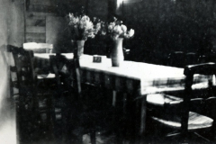 Innenraum mit Tisch, Stühlen und Blumenvase