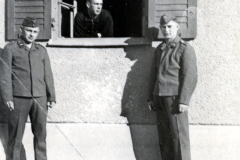 Drei Soldaten vor Gebäudeeingang mit Fenster