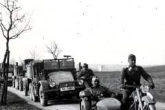 Motorradkolonne mit Beiwagen und Lastkraftwagen auf Landstraße