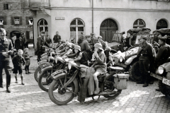 Militärische Fahrzeugparade mit Motorrädern und Kraftwagen auf Marktplatz