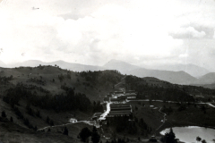Industrieanlage in Berglandschaft mit Flusstal und Seen