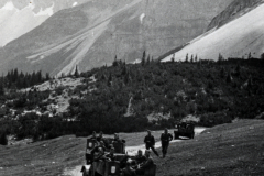 Militärkonvoi in Gebirgslandschaft mit Lastkraftwagen und Soldaten