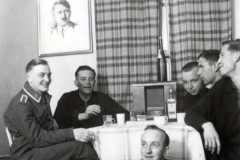 Männergruppe in Innenraum mit Porträt an der Wand