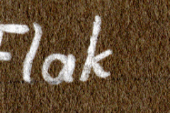 Handschriftliche Aufschrift 'Durch Flak erledigt' auf Textiluntergrund