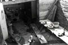 Küche in einem Bunker oder Unterstand mit Essgeschirr und Kochutensilien
