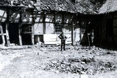 Zerstörter Innenhof mit Ruinen und Personen in kriegszerstörtem Gebäude