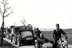 Motorradkolonne mit Beiwagen und Lastkraftwagen auf Landstraße