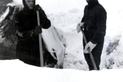 Zwei Personen mit Schaufeln in Schneegelände