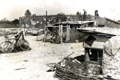 Zerstörte Siedlung mit Fahrrädern und Trümmern