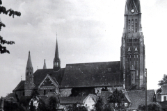 Kirchenensemble mit hohem Kirchturm in niederländischer Landschaft