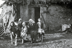 Gruppe von Kindern und Frauen vor provisorischer Behausung