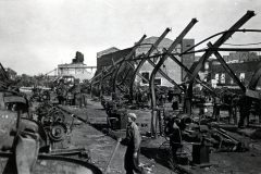 Zerstörte Industrieanlage mit Arbeitern und Maschinenteilen
