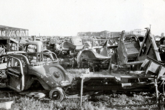 Schrottplatz mit zerstörten Fahrzeugen und Kriegsschrott