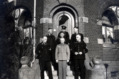 SS-Angehörige mit Junge in Uniform vor Backsteingebäude