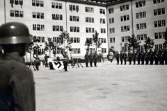 SS-Formationen mit Hakenkreuzfahnen auf Innenhofplatz