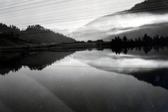 Bergsee mit Nadelwaldbestand und Nebelbildung