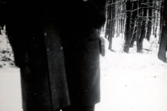 Zwei Personen in Winterkleidung in verschneiter Waldlandschaft